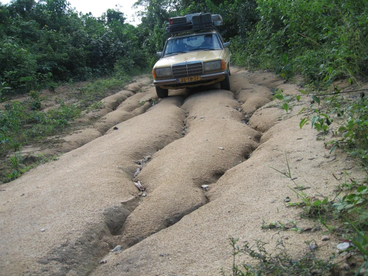 an suv is driving down the dirt road