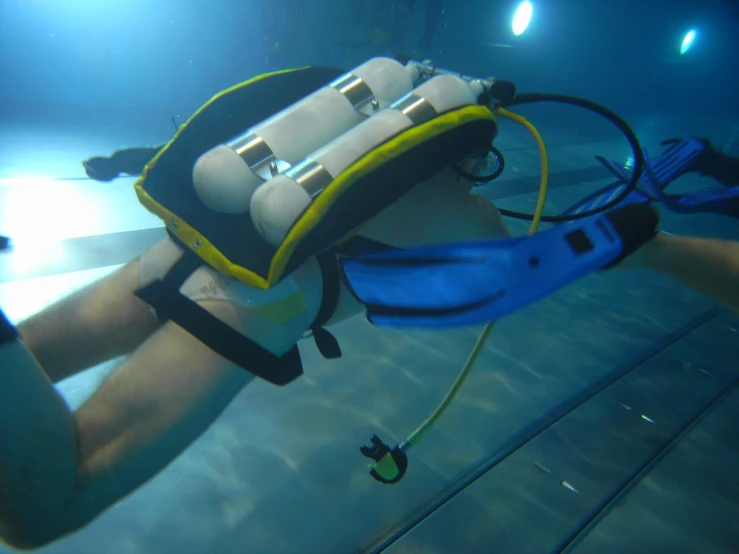 a man in a scuba suit holding onto an underwater device