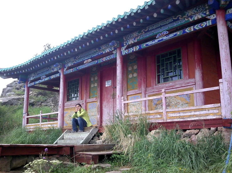 the women are taking pictures in front of the red building