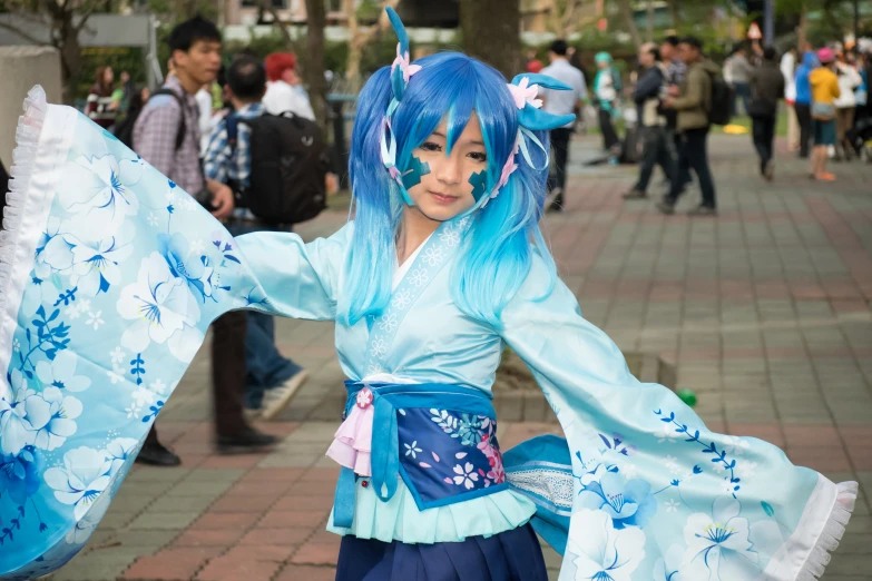 a woman dressed in a blue costume with blue hair holding a big blue umbrella