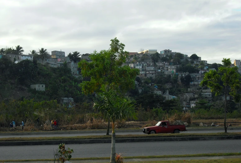 a view of a mountain with houses and a red pickup truck