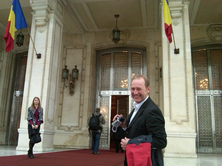 there is a man in a suit that has a red bag