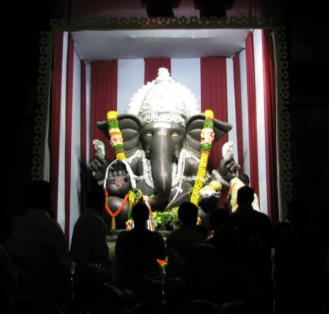 a large statue of a elephant on display in front of a crowd
