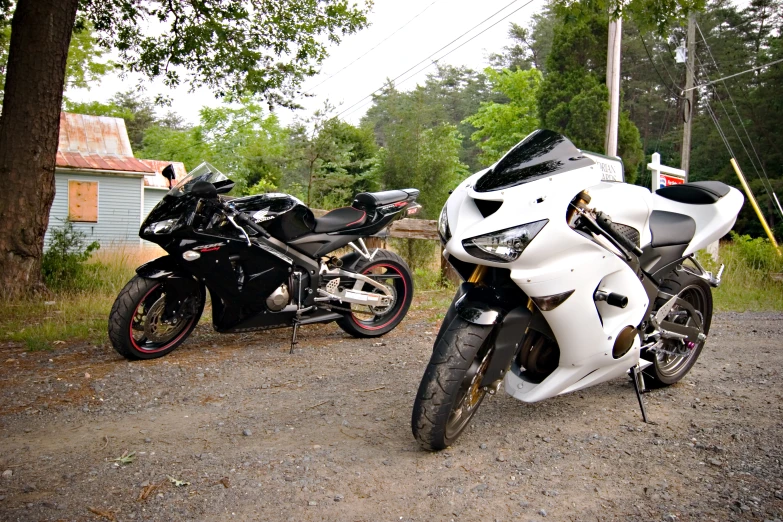 two motorcycles are sitting on the side of a road