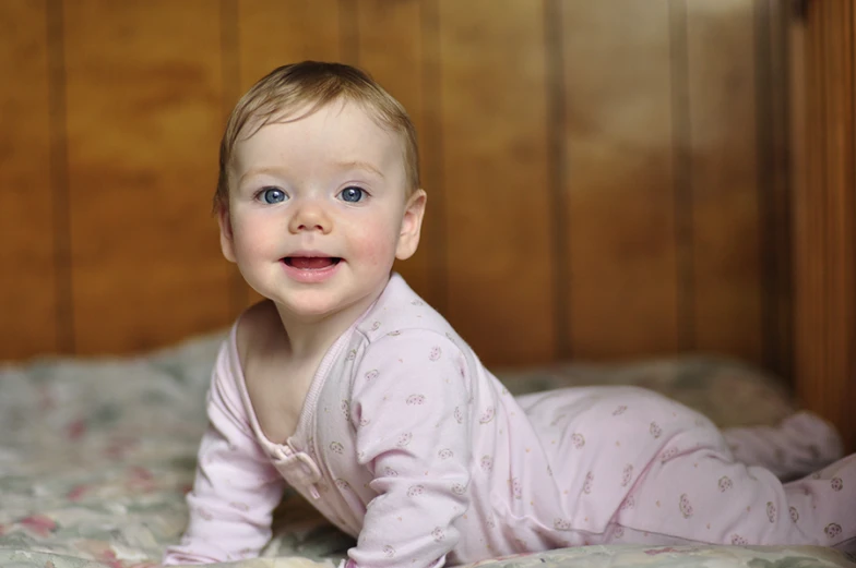 a little baby laying down on a bed