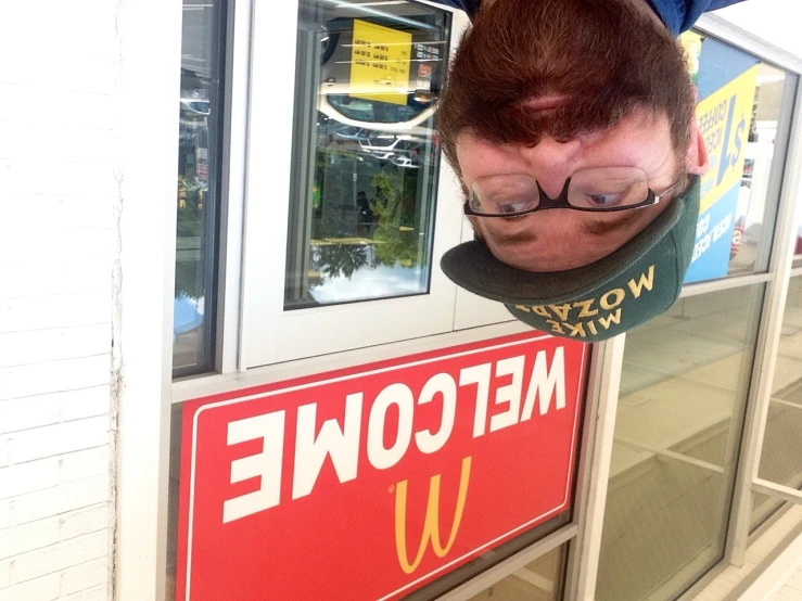 a man with a beard, in front of a mcdonalds sign