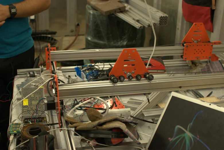 a robot made with many different components, and a man standing next to it