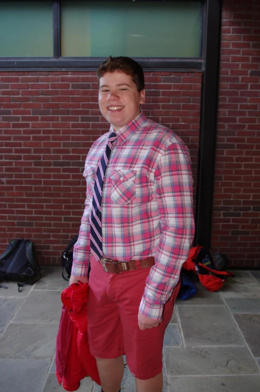 a young man in shorts, a on up shirt, tie and shoes