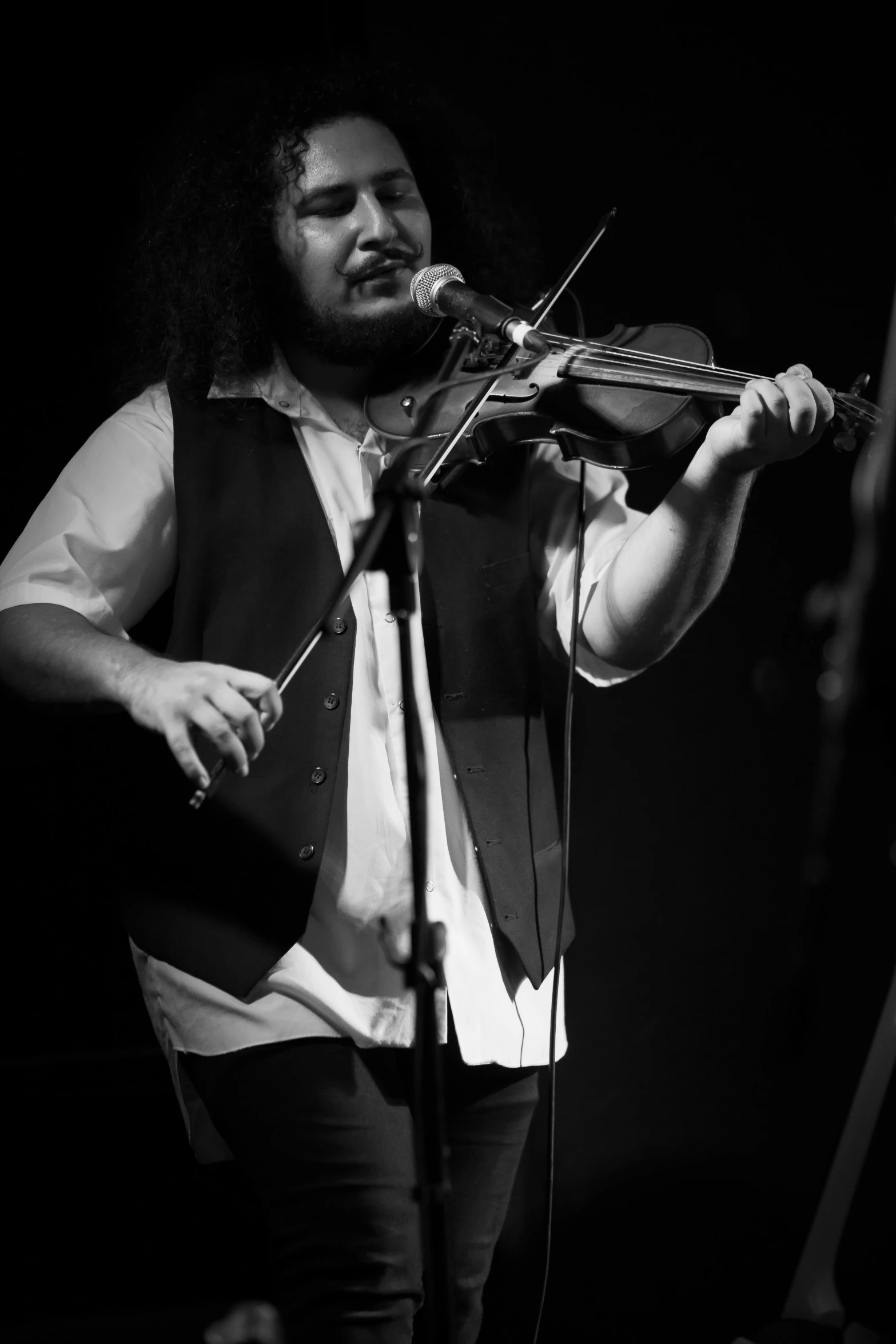 a black and white po of a man playing the violin