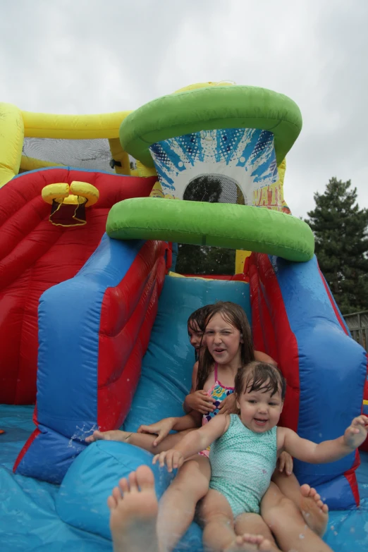 children sitting in an inflatable slide at a fun birthday party