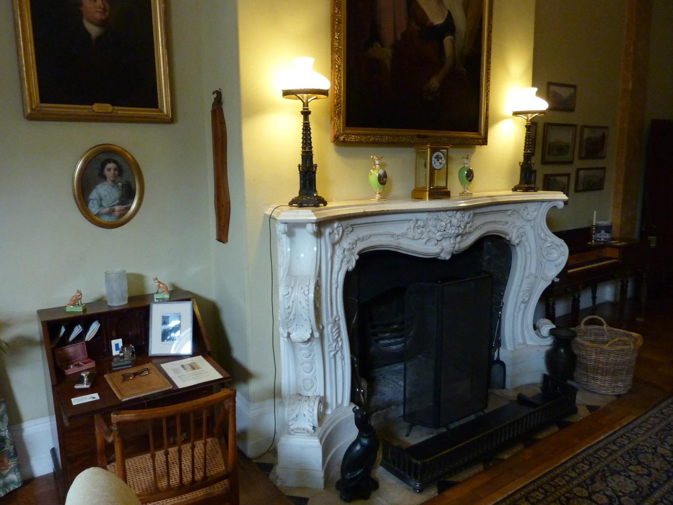 fireplace with painting in background and artwork on wall