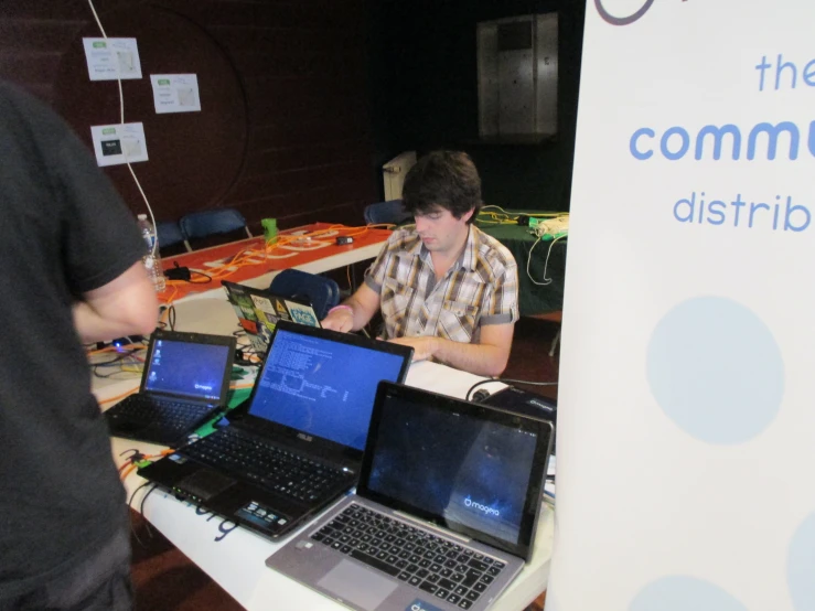 people sitting around a table with laptops