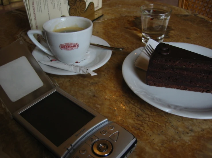 a cell phone and some cake sitting on a table