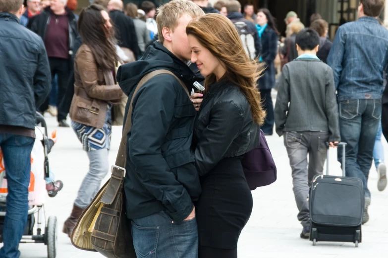 a man and woman are walking in front of a crowd