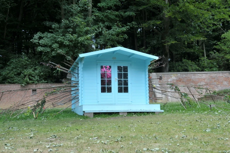 a small blue out house with an open door
