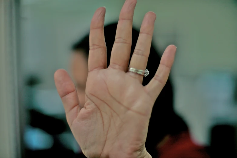 a hand is outstretched and has an engagement ring on it