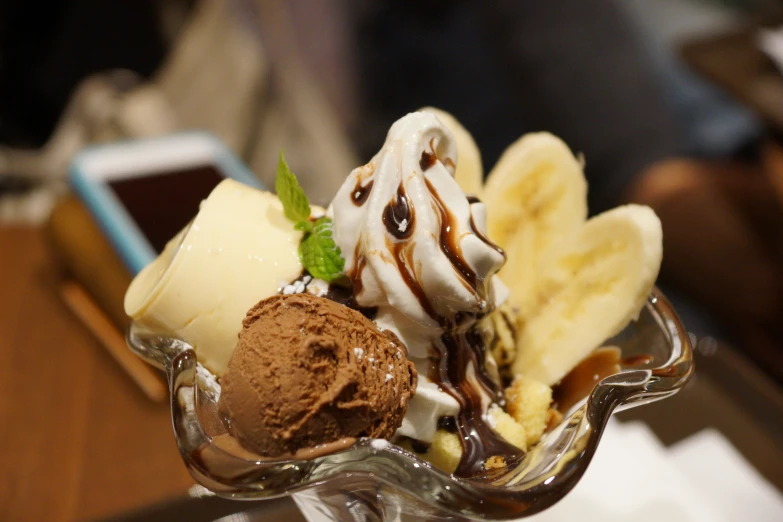 a glass bowl with different types of ice cream and bananas