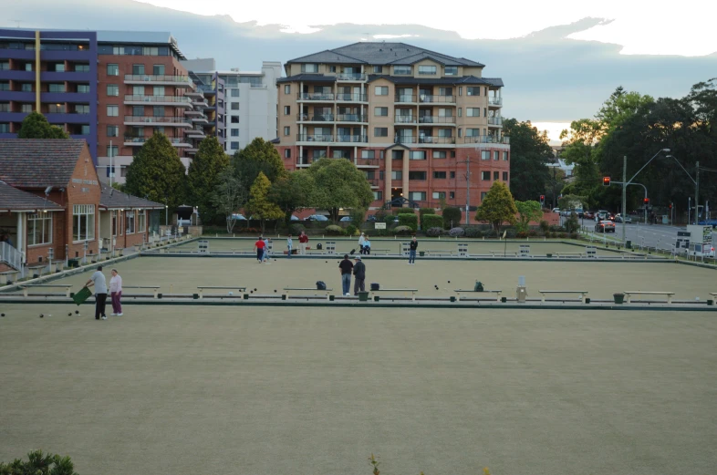 an empty parking lot with several people walking in the distance