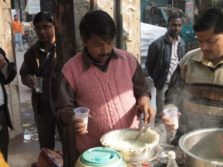 men are cooking soing on a street side