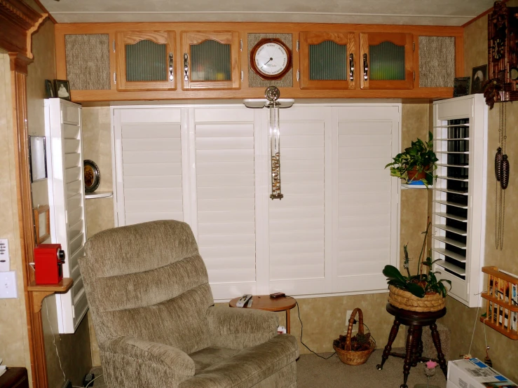 a living room with shutters closed and a large recliner