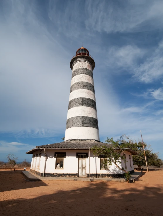 a large white and grey tower with a blue sky behind it