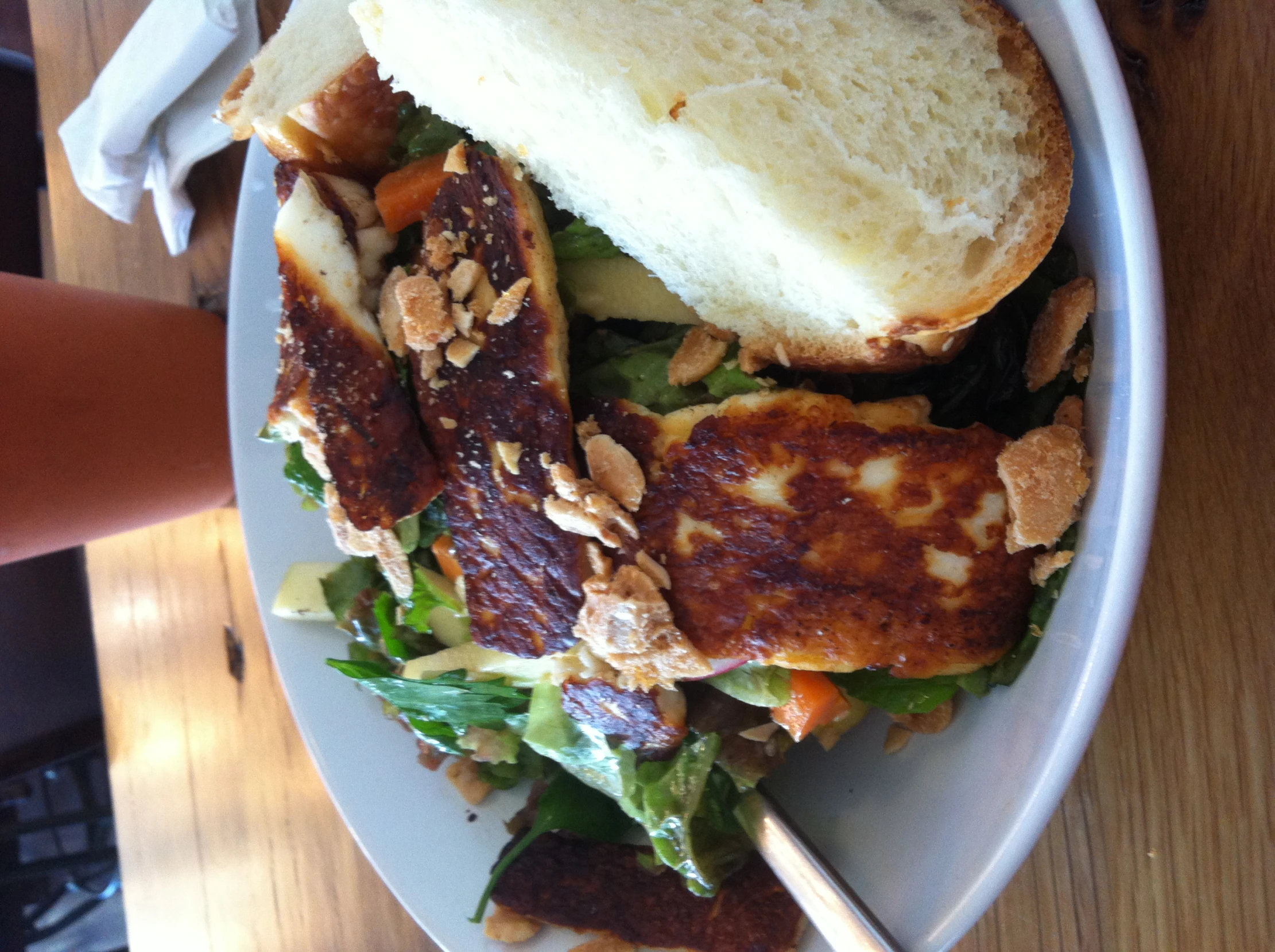 a salad with lettuce and chicken on it, next to some toast