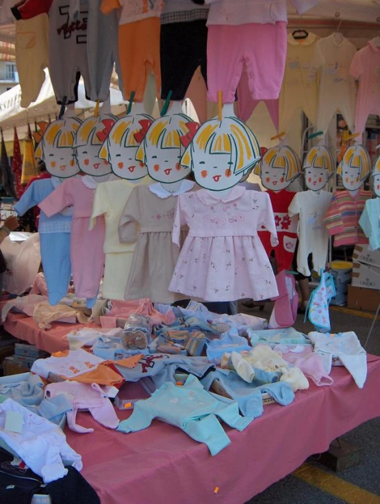 lots of baby clothes and toys hanging on a rack