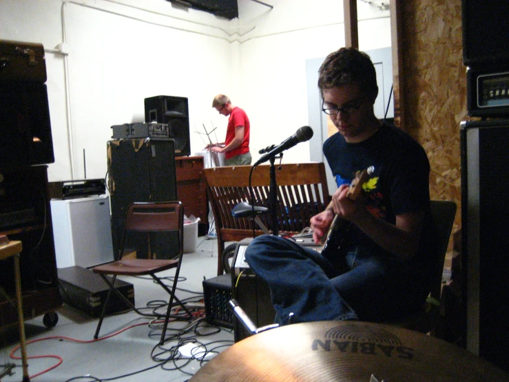 a band player in the background in front of a microphone and an amp
