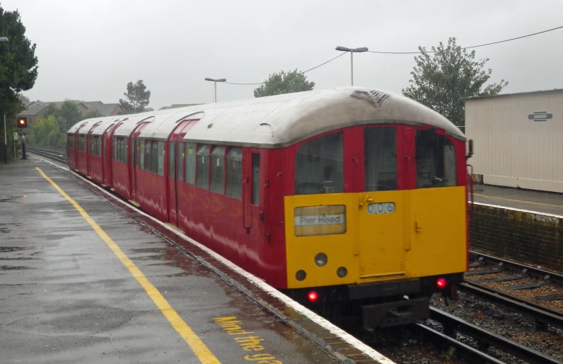 there is a train that is traveling in the rain