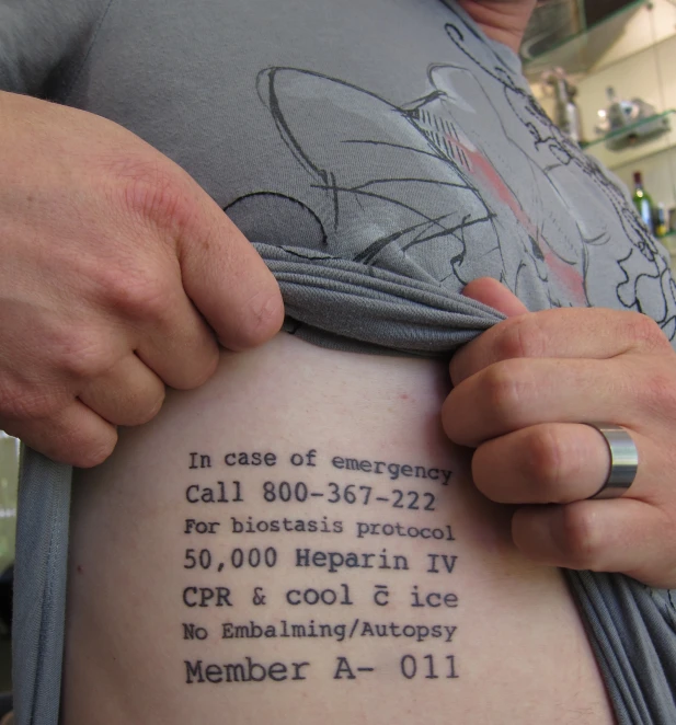 a person holding on to a tattoo reading in case of emergency