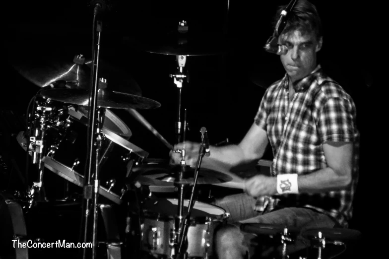 a man playing a drums on stage with some other instruments