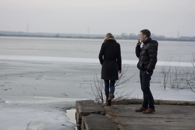 two people standing next to each other looking at soing in the distance