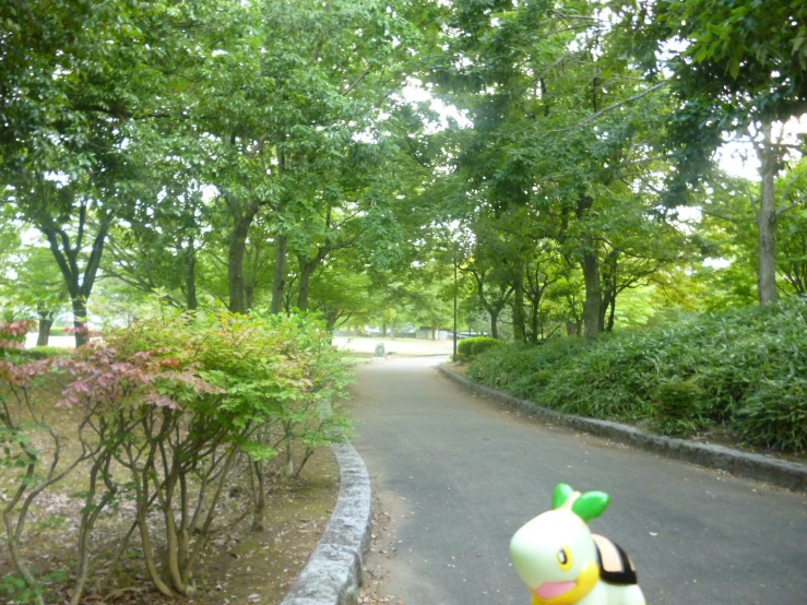 a small plastic toy next to a pathway through a park