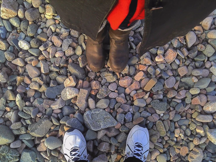 a pair of legs standing on a pile of rocks