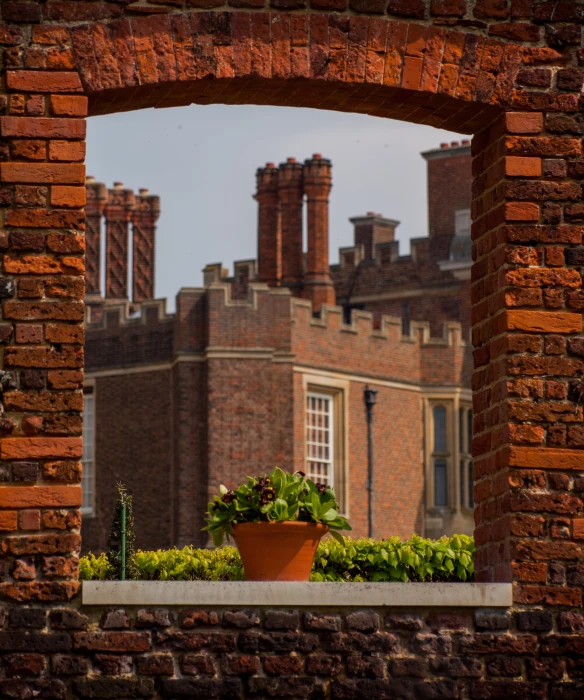 a brick building with a plant in a pot outside