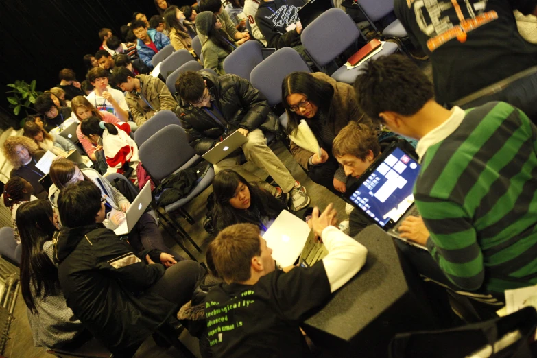 a crowd of students sitting in rows in the lecture hall