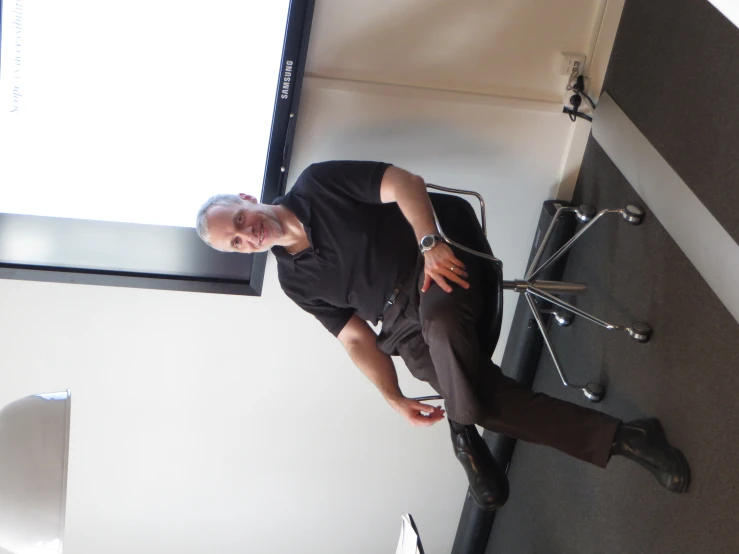 a man sitting in front of a projection screen