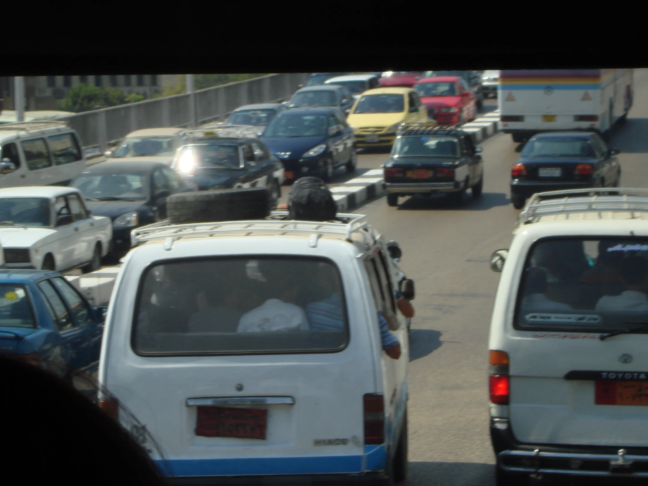 a group of cars driving down the road next to each other