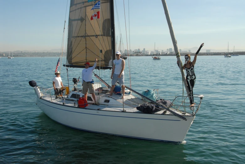 a group of men standing on top of a sail boat