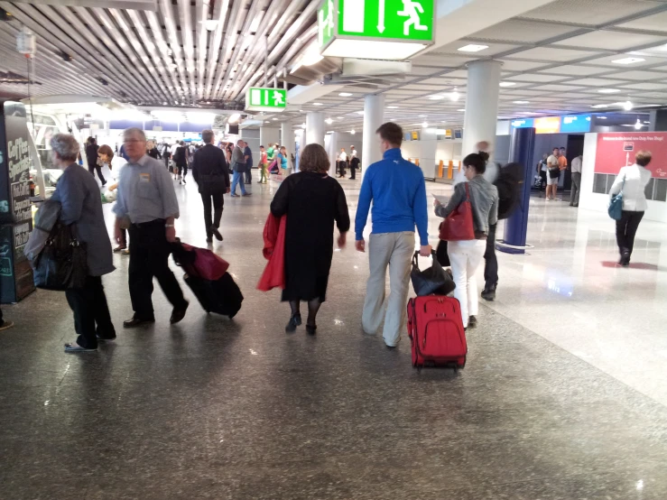 many people and luggage are walking through an airport