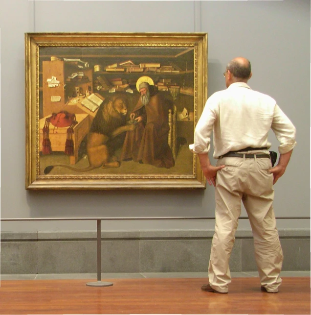 a man standing next to a painting on display