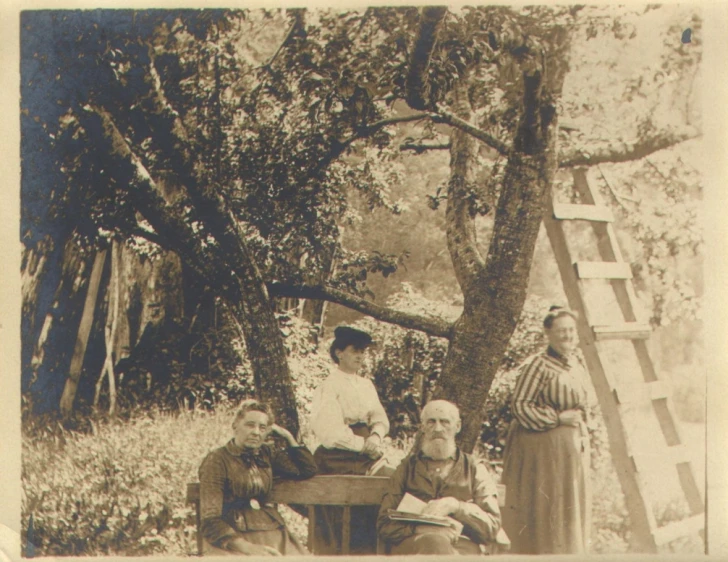 an old black and white po with people in a wooden wagon