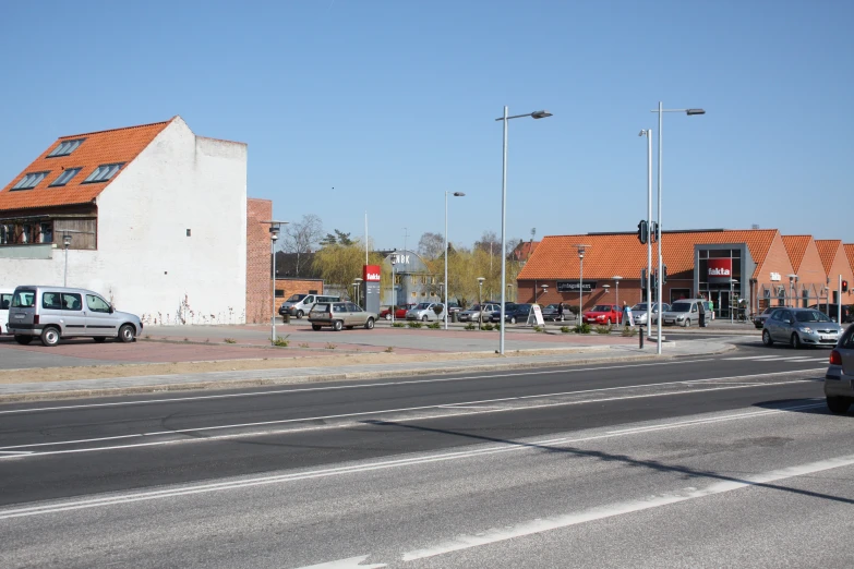 a couple of white vans are parked by some buildings