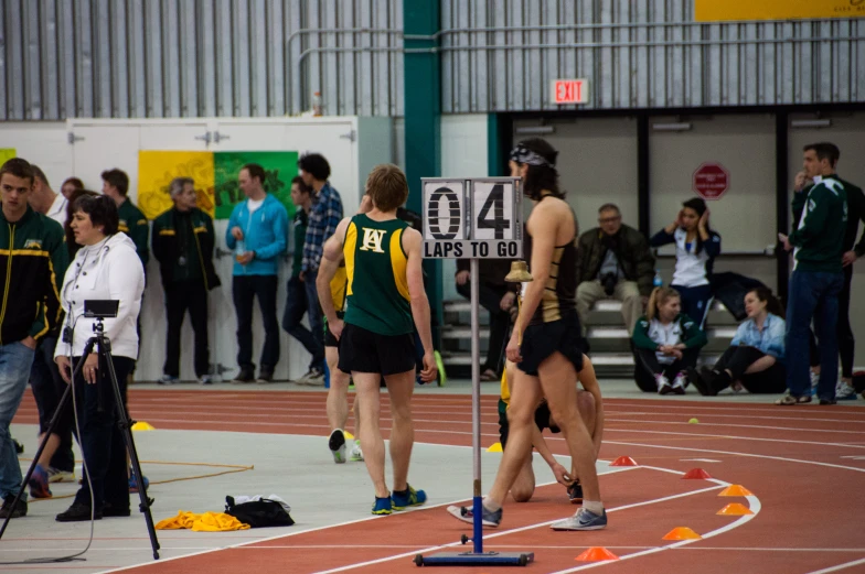 some people on a track with cameras and a sign