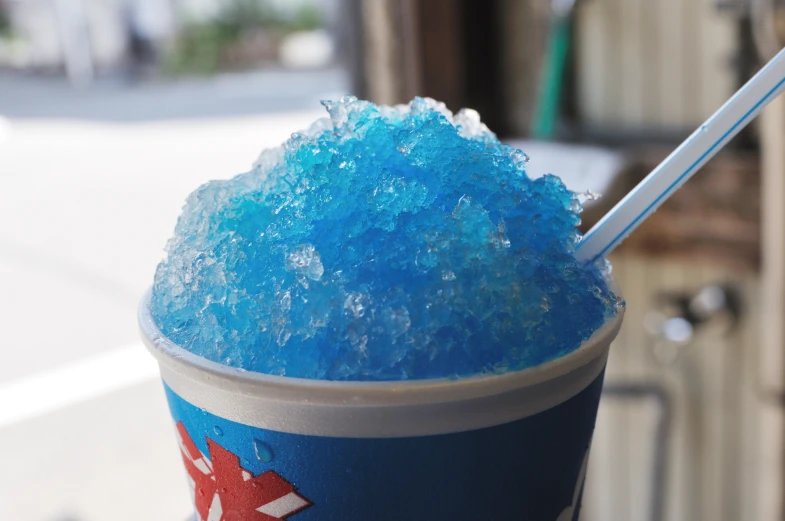 blue colored ice cream is on top of a plastic cup