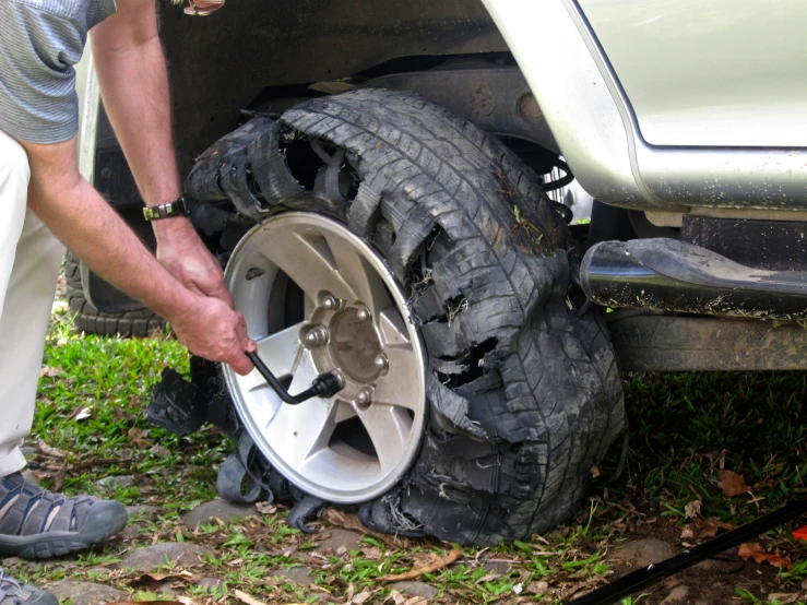 a man on a grass field is fixing a tire