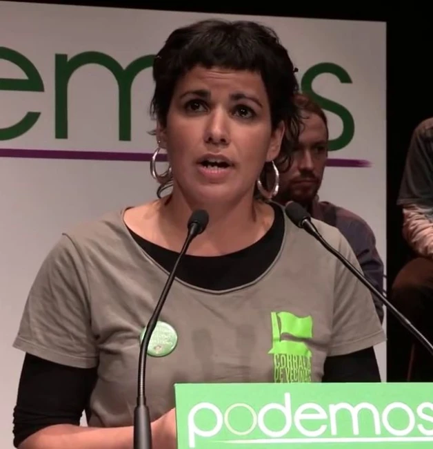 a woman talking at a podium in front of some microphones