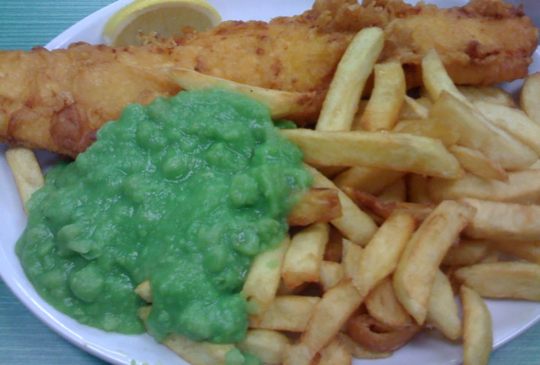 there is french fries and peas on the plate
