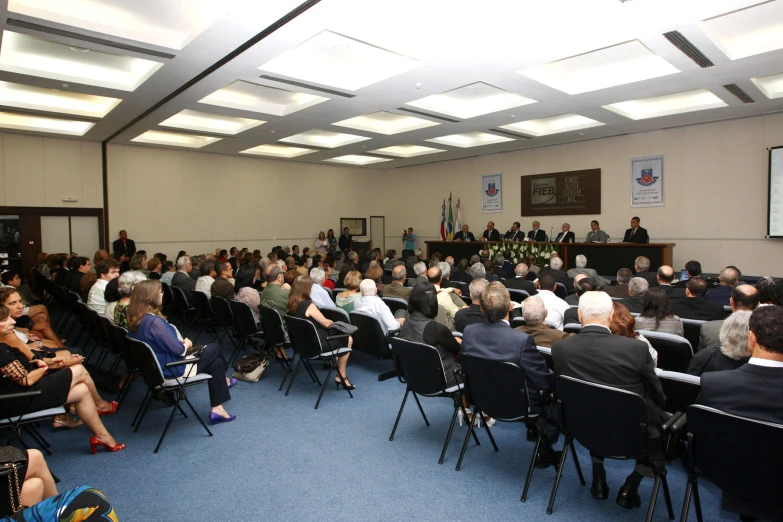 a large crowd is gathered in the conference room for an assembly