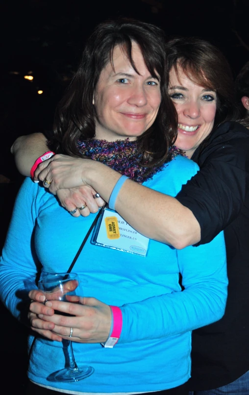 two women in blue hugging each other at an event